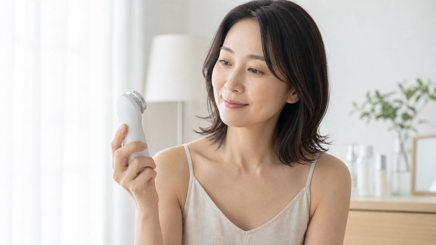 美容家電を手に持つ女性