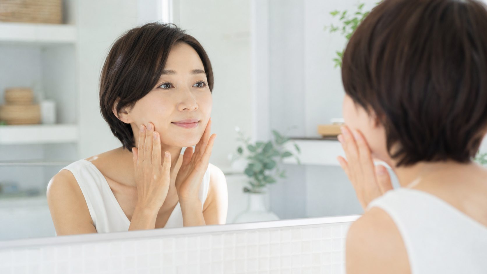 鏡の前でスキンケアをする40代の女性